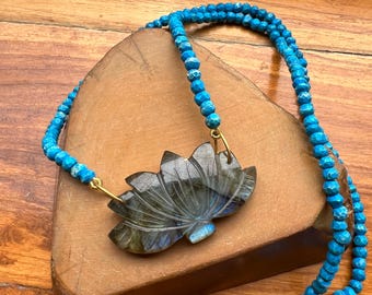 May include: A blue gemstone lotus flower pendant necklace with a turquoise beaded chain.