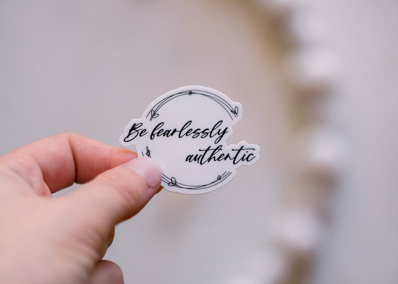 May include: White sticker with a black circle and the text "Be fearlessly authentic" inside.