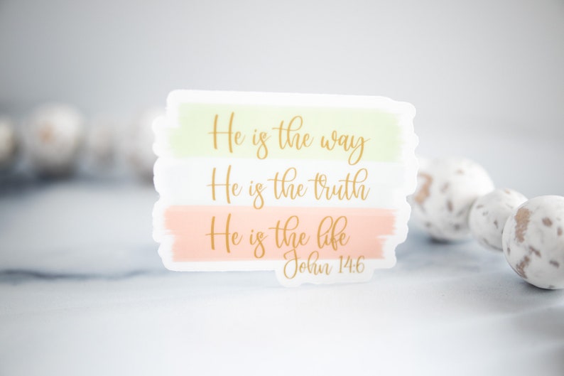 Pode incluir: Um adesivo com fundo verde pastel, branco e p&ecirc;ssego. O adesivo apresenta o texto "He is the way, He is the truth, He is the life, John 14:6" em letras douradas.