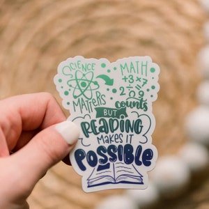 Puede incluir: Una pegatina con un dise&ntilde;o verde y azul que dice "Science Matters But Reading Makes It Possible". La pegatina tambi&eacute;n incluye un s&iacute;mbolo de &aacute;tomo verde y ecuaciones matem&aacute;ticas.