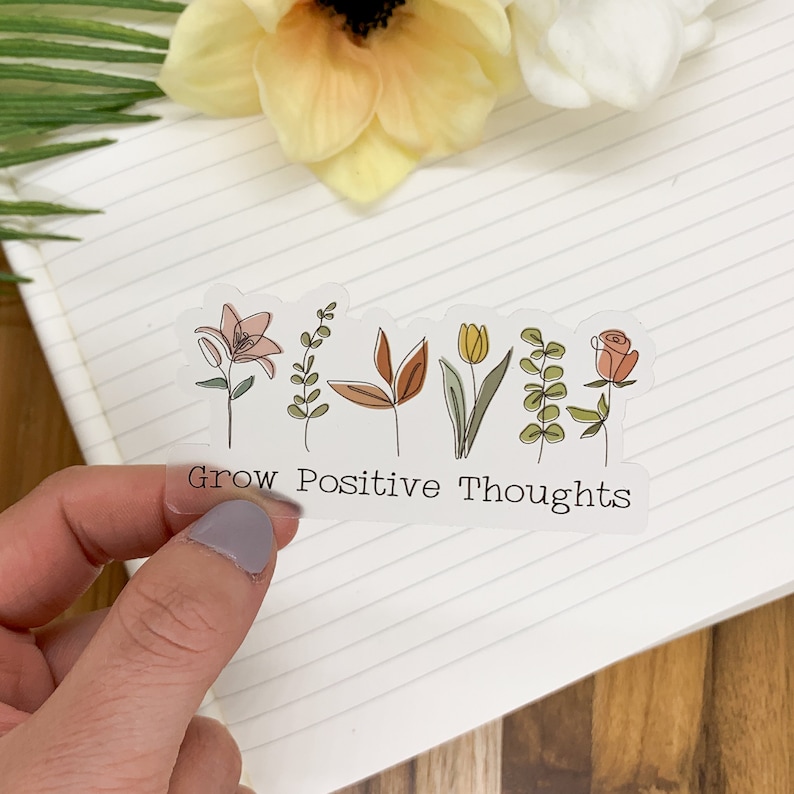 May include: A clear sticker with a line drawing of flowers and the text "Grow Positive Thoughts".