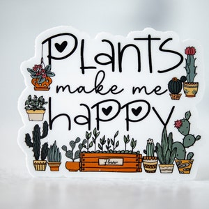 May include: White sticker with black text that reads "Plants make me happy" surrounded by illustrations of potted plants. The plants include cacti, succulents, and leafy plants.