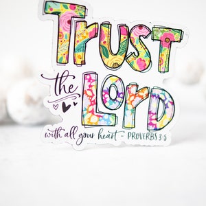 May include: A colorful sticker with the text "Trust the Lord with all your heart - Proverbs 3:5". The letters are outlined in black and filled with a floral pattern.