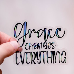 May include: A clear sticker with the text "grace changes EVERYTHING" in black script. The word "grace" is iridescent with rainbow colors.