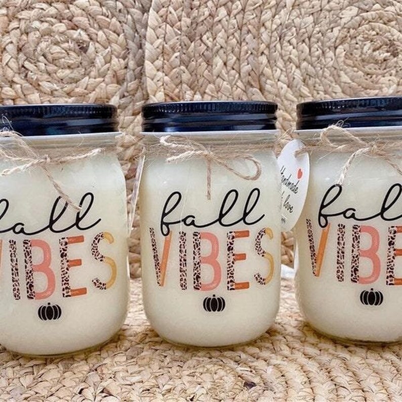 K&ouml;nnte beinhalten: Drei Glasbeh&auml;lter mit wei&szlig;en Deckeln und einem wei&szlig;en Etikett mit dem Text "fall vibes" in schwarzer Schrift mit Leopardenmuster. Die Beh&auml;lter sind mit einer wei&szlig;en Substanz gef&uuml;llt und stehen auf einer gewebten Oberfl&auml;che.