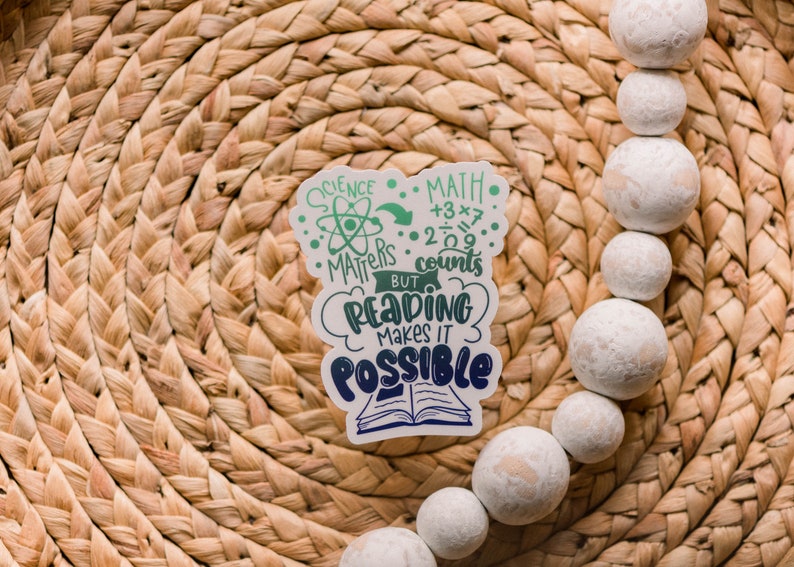 Puede incluir: Una pegatina blanca con texto verde y azul que dice "Science Matters, Math Counts, But Reading Makes It Possible". La pegatina presenta un s&iacute;mbolo de &aacute;tomo y un libro.