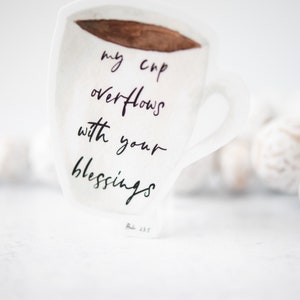 May include: White coffee mug sticker with the text "my cup overflows with your blessings" and the scripture reference "Ps 23:5".