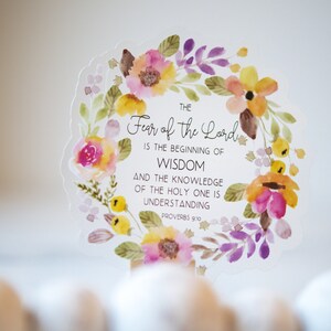 May include: A watercolour floral wreath with a white background and the text "THE Fear of the Lord IS THE BEGINNING OF WISDOM AND THE KNOWLEDGE OF THE HOLY ONE IS UNDERSTANDING PROVERBS 9:10".