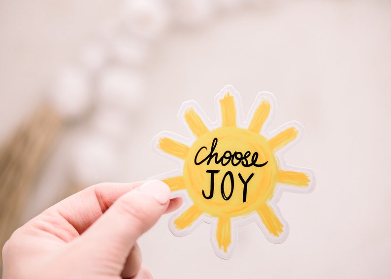 May include: A yellow sun sticker with the words "Choose Joy" written in black.
