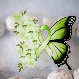 K&ouml;nnte beinhalten: Ein Aufkleber mit einem Schmetterlingsdesign mit einem gr&uuml;nen Band und Rosen. Der Schmetterling hat einen gr&uuml;nen Fl&uuml;gel mit schwarzen Akzenten. Die andere Seite zeigt eine Ansammlung von hellgr&uuml;nen Rosen und Bl&auml;ttern.