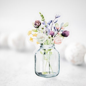 May include: A watercolor illustration of a bouquet of flowers in a clear glass jar. The flowers are in shades of purple, pink, yellow, and white.