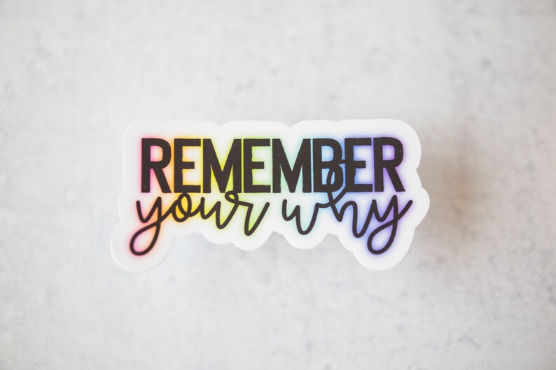 May include: A white sticker with a rainbow gradient background and black text that reads "REMEMBER your why".