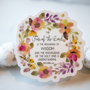 May include: A white sticker with a watercolour floral wreath surrounding the text "THE Fear of the Lord IS THE BEGINNING OF WISDOM AND THE KNOWLEDGE OF THE HOLY ONE IS UNDERSTANDING PROVERBS 9:10".