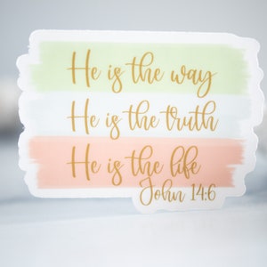 Pode incluir: Um adesivo com fundo verde claro, branco e rosa claro. O adesivo tem letras douradas que dizem "Ele &eacute; o caminho, Ele &eacute; a verdade, Ele &eacute; a vida, Jo&atilde;o 14:6".