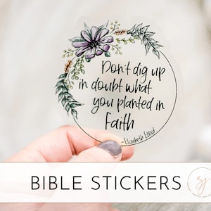 May include: A clear sticker with a floral wreath and the quote "Don't dig up in doubt what you planted in Faith - Elizabeth Elliot". The sticker is part of a set of Bible stickers.