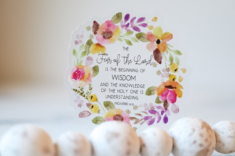 May include: A watercolour floral wreath with a white background and the text "THE Fear of the Lord IS THE BEGINNING OF WISDOM AND THE KNOWLEDGE OF THE HOLY ONE IS UNDERSTANDING PROVERBS 9:10".