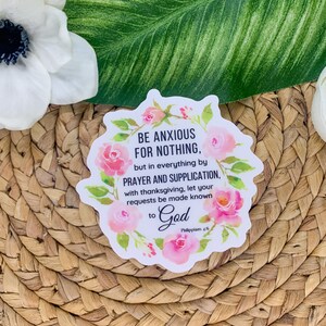 May include: A white sticker with a pink floral border and the text "BE ANXIOUS FOR NOTHING, but in everything by PRAYER AND SUPPLICATION, with thanksgiving, let your requests be made known to God Philippians 4:6".