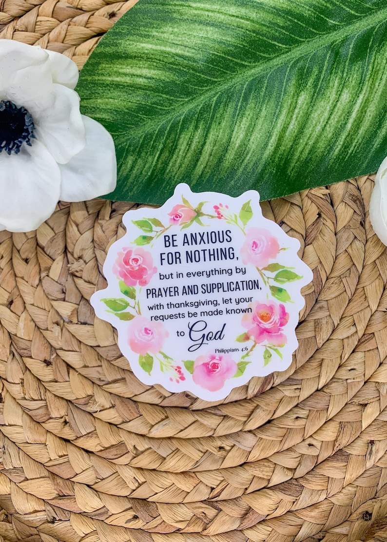May include: A white sticker with a pink floral border and the text "BE ANXIOUS FOR NOTHING, but in everything by PRAYER AND SUPPLICATION, with thanksgiving, let your requests be made known to God Philippians 4:6".