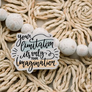 May include: A white sticker with the text "your limitation it's only your imagination" in black script. The sticker has a blue, green, and orange striped background.