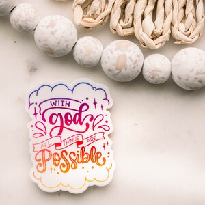 May include: A white sticker with a rainbow gradient design that says "With god all things are possible." The sticker has a cloud-like shape and is on a white background.
