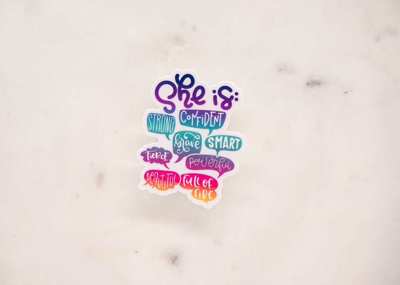 Puede incluir: Una pegatina colorida con el texto "She is: strong, confident, brave, smart, fierce, powerful, beautiful, full of fire".