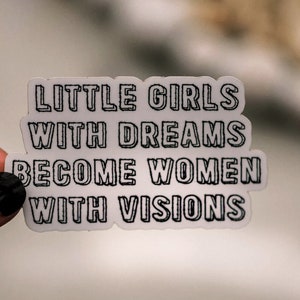 May include: White sticker with black text that reads "Little girls with dreams become women with visions".
