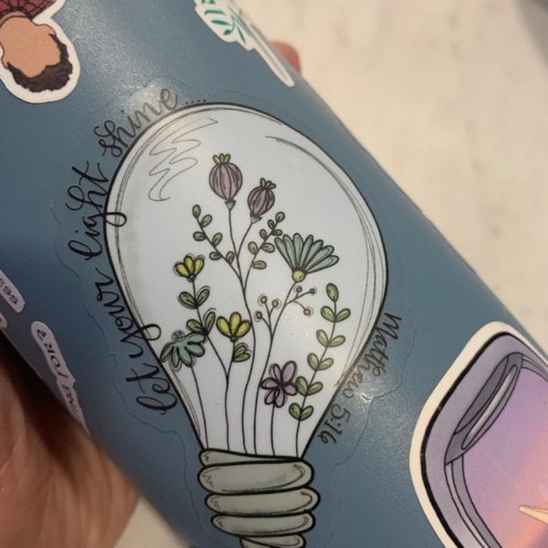 May include: A light blue water bottle with a white sticker that says "Let your light shine... Matthew 5:16" and a light bulb with flowers inside.