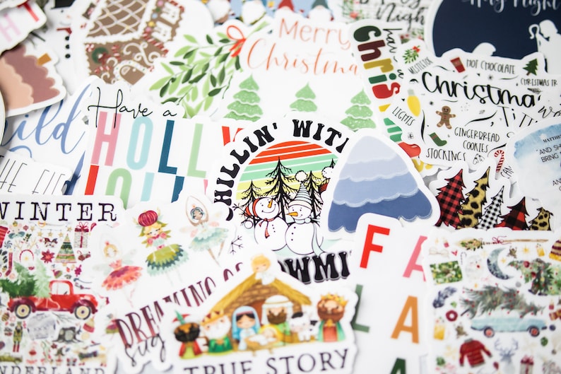 K&ouml;nnte beinhalten: Eine Sammlung von Weihnachtsaufklebern mit verschiedenen Designs, darunter ein Schneemann, ein Lebkuchenhaus, ein Weihnachtsbaum und der Text "Have a Holly Jolly Winter".