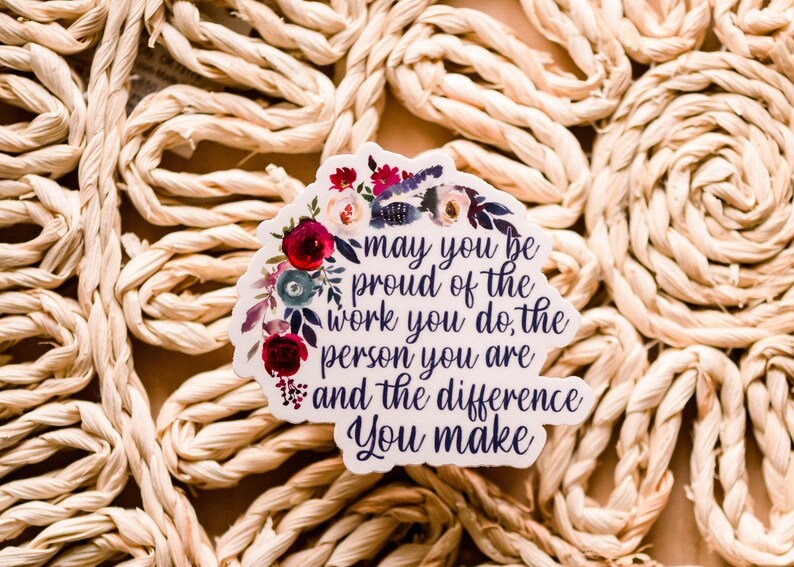 May include: A white sticker with a floral design and the text "may you be proud of the work you do, the person you are and the difference you make".