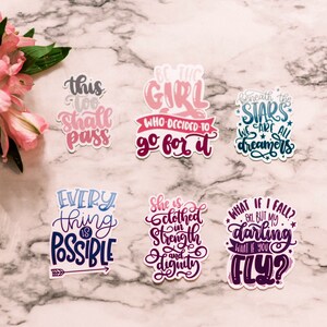 May include: A set of six colorful stickers with inspirational quotes. The stickers feature a variety of fonts and colors, including pink, blue, purple, and gray. The quotes include "This too shall pass", "Be the girl who decided to go for it", "Beneath the stars we are all dreamers", "Every thing is possible", "She is clothed in strength and dignity", and "What if I fall? Oh but my darling what if you fly?"