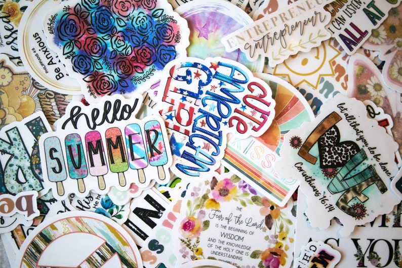 May include: Assortment of colorful stickers with various designs and phrases, including "hello summer", "cute", "entrepreneur", and a heart with the words "let all that you do be done in love" and "Corinthians 16:14".