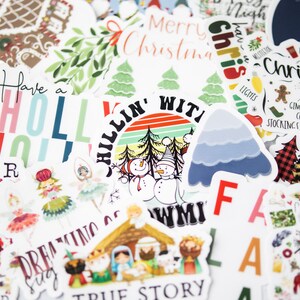 Puede incluir: Una colecci&oacute;n de pegatinas con tem&aacute;tica navide&ntilde;a que presentan varios dise&ntilde;os, incluyendo un mu&ntilde;eco de nieve, una casa de jengibre, un &aacute;rbol de Navidad y el texto "Have a Holly Jolly Winter".