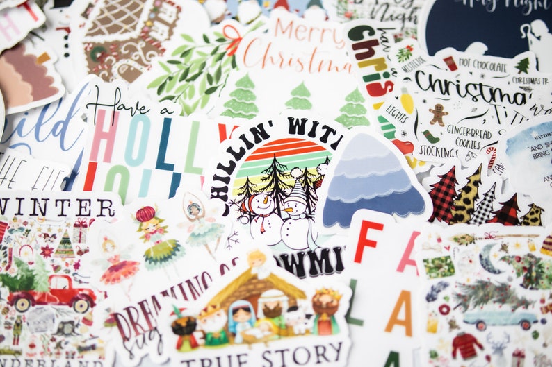 Puede incluir: Una colecci&oacute;n de pegatinas con tem&aacute;tica navide&ntilde;a que presentan varios dise&ntilde;os, incluyendo un mu&ntilde;eco de nieve, una casa de jengibre, un &aacute;rbol de Navidad y el texto "Have a Holly Jolly Winter".