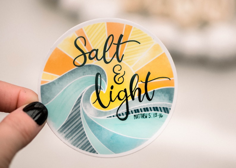 May include: A round sticker with a watercolor design of a wave and a sunburst. The sticker says "Salt & Light" with the scripture reference "Matthew 5:13-16" underneath.