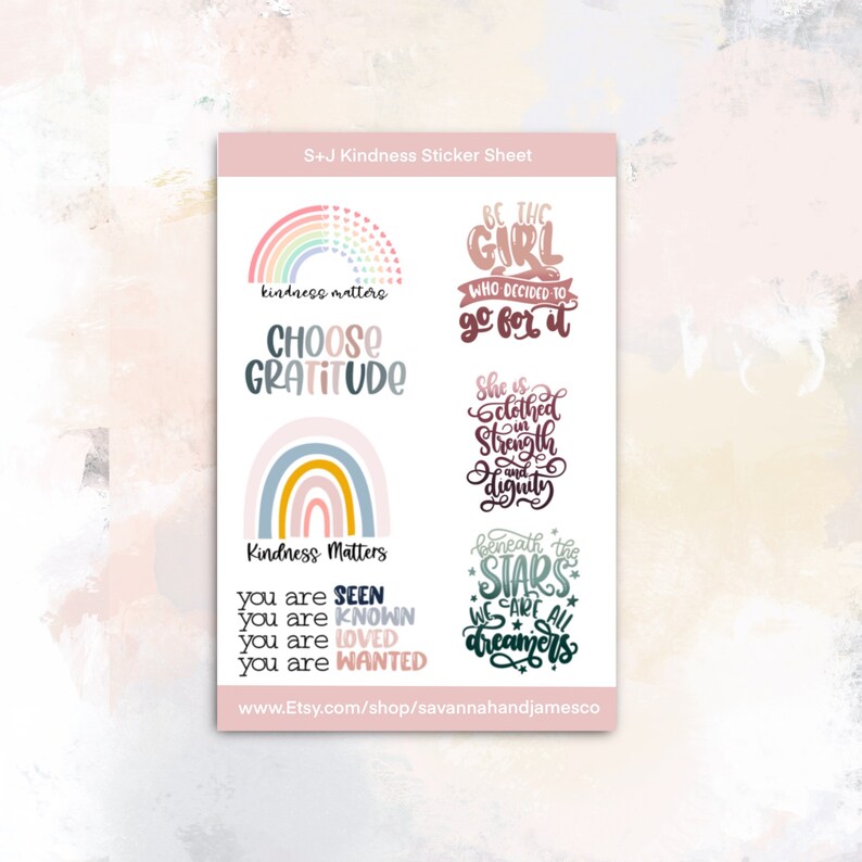 May include: A sticker sheet with a pink background and colorful stickers featuring positive messages. The stickers include a rainbow with the text "kindness matters", a rainbow with the text "Kindness Matters", a rainbow with the text "Choose Gratitude", a girl with the text "Be the girl who decided to go for it", a girl with the text "She is clothed in strength and dignity", and a star with the text "Beneath the stars we are all dreamers".