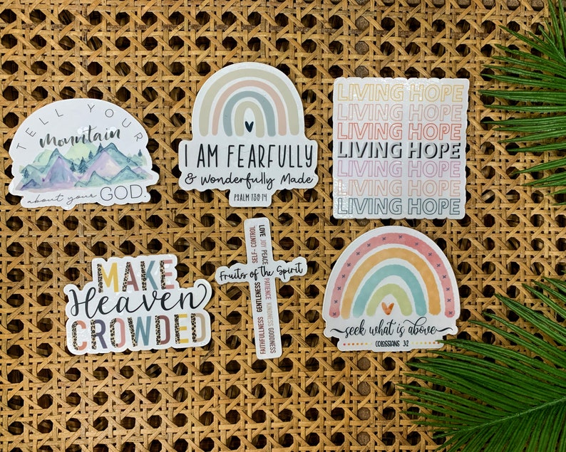 May include: Six colorful stickers with religious quotes and designs. The stickers feature rainbows, mountains, a cross, and the words "Living Hope", "I am fearfully and wonderfully made", "Tell your mountain about your God", "Make Heaven Crowded", and "Seek what is above".