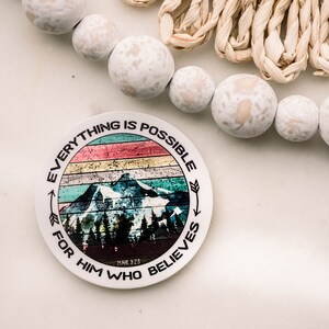 May include: A round sticker with a colorful mountain scene and the text "Everything is possible for him who believes" with the scripture reference "Mark 9:23".