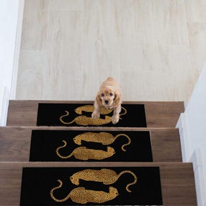 May include: Three rectangular black stair treads, each featuring a repeating pattern of two golden-yellow leopards with black spots. The leopards are positioned in a mirrored, horizontal orientation across the center of each individual stair tread.
