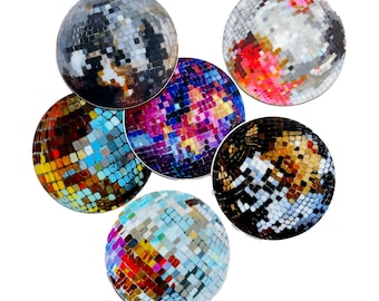 Op de afbeelding: Zes kleurrijke discoballen met gespiegelde tegels. De ballen zijn in een cirkel gerangschikt, met de bovenste bal iets uit het midden. De ballen zijn in verschillende kleuren, waaronder blauw, groen, rood, paars en zwart.