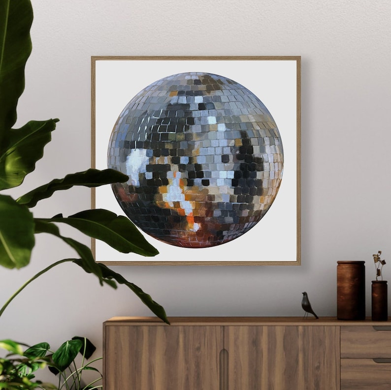 May include: A framed painting of a silver disco ball on a white background. The disco ball is made up of many small, mirrored squares.