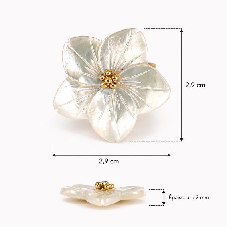 May include: A flower-shaped ring with a pearlescent finish. The ring's petals are white with subtle veining, and the center features a cluster of small, gold-colored beads. The ring measures approximately 1.1 inches in diameter and has a thickness of 0.08 inches.