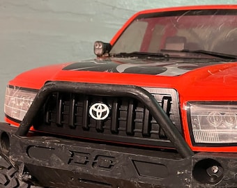 Parrilla delantera estilo Toyota Axial SCX6 Honcho, actualizada con un punto con el logotipo, sin pintar (gris)