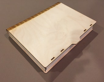 Peut inclure: Une boîte en bois de couleur claire, conçue comme un livre. La boîte rectangulaire a un couvercle et un bord décoratif texturé. Fabriquée en bois clair, elle présente un design simple et minimaliste. Idéale pour le rangement.