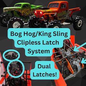 May include: A close-up of a red and black monster truck chassis with a clip-less latch system. The chassis has two latches, one on each side. The latches are black and have a silver spring. The chassis is made of metal and has a black and red paint job. The truck is called "Bog Hog".