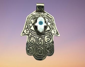 Fatima's Hand (Hamza) shaped pendant with a small mother of pearls hand and God’s eye design in the middle.