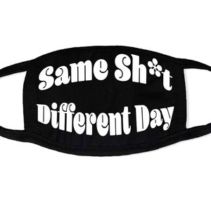 May include: Black face mask with white text that reads "Same Sh*t Different Day" in a retro font.