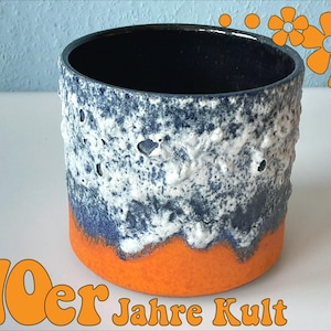 May include: A cylindrical ceramic vase with a textured white, blue, and orange design. The interior is dark blue. The base is orange, and the sides have a textured, speckled appearance. The text "70er Jahre Kult" is in orange.