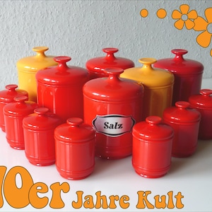 Peut inclure: Ensemble de dix pots en céramique vintage rouge et jaune avec couvercles. Les pots sont étiquetés avec le mot "Salz" (allemand pour sel).