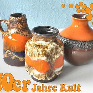Könnte beinhalten: Drei Vintage-Keramikvasen mit orange, braunen und schwarzen Farbtönen. Eine Vase hat einen Henkel, eine andere ein strukturiertes Band, und die dritte hat eine runde Form. Der Text "70er Jahre Kult" ist orange dargestellt.