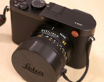 Cover for Leica Q lens cap with lanyard attachment in black color